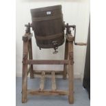 An artisan two part butter churn and stand, the coopered barrel with a lid, iron catches, a crank