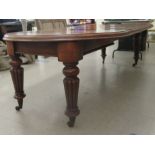 An early Victorian mahogany wind-out dining table, comprising two D-ends, raised on bulbous and reed