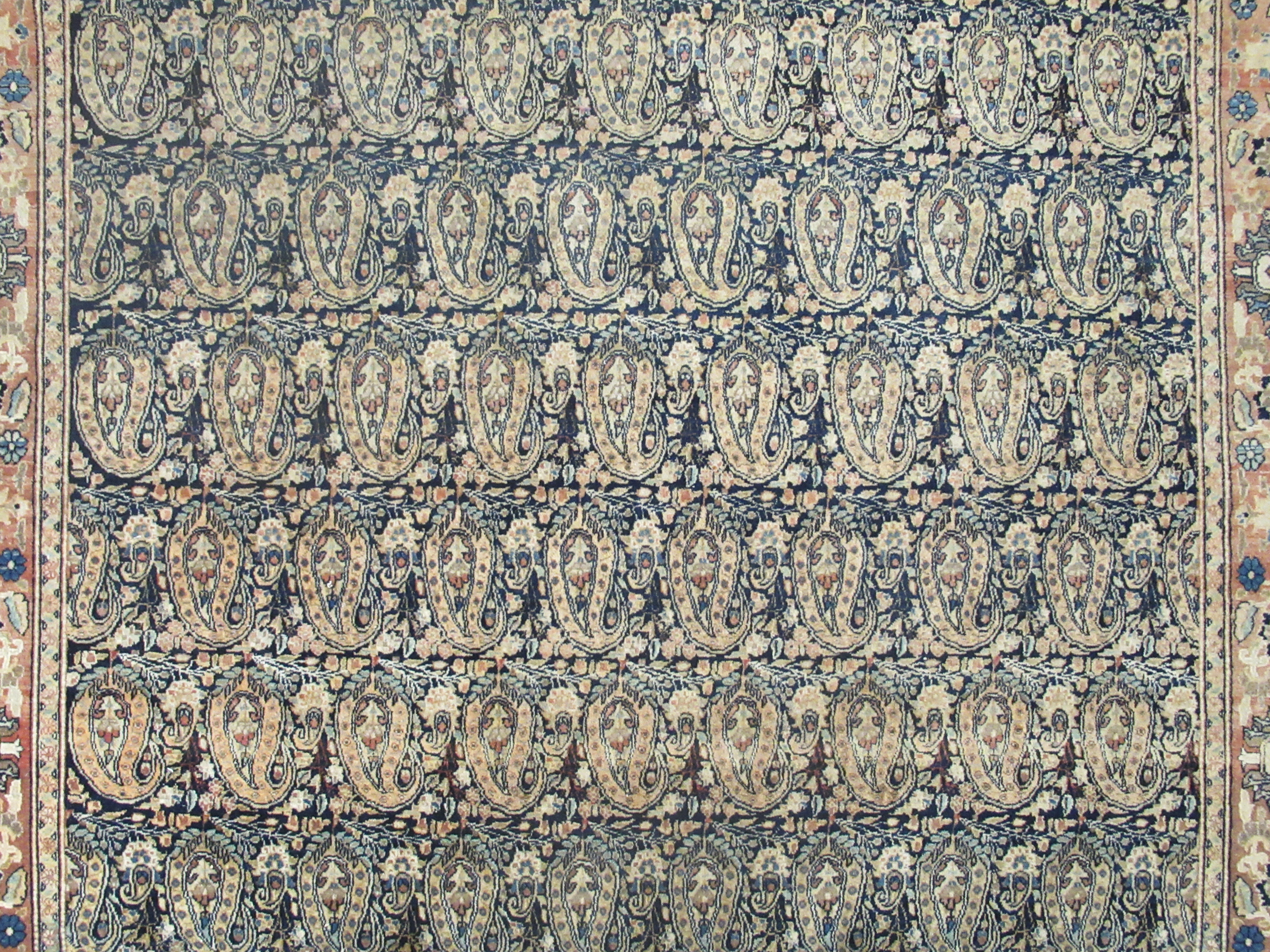 A Persian rug, decorated with repeating stylised designs, bordered by flora and foliage, on a - Image 2 of 5