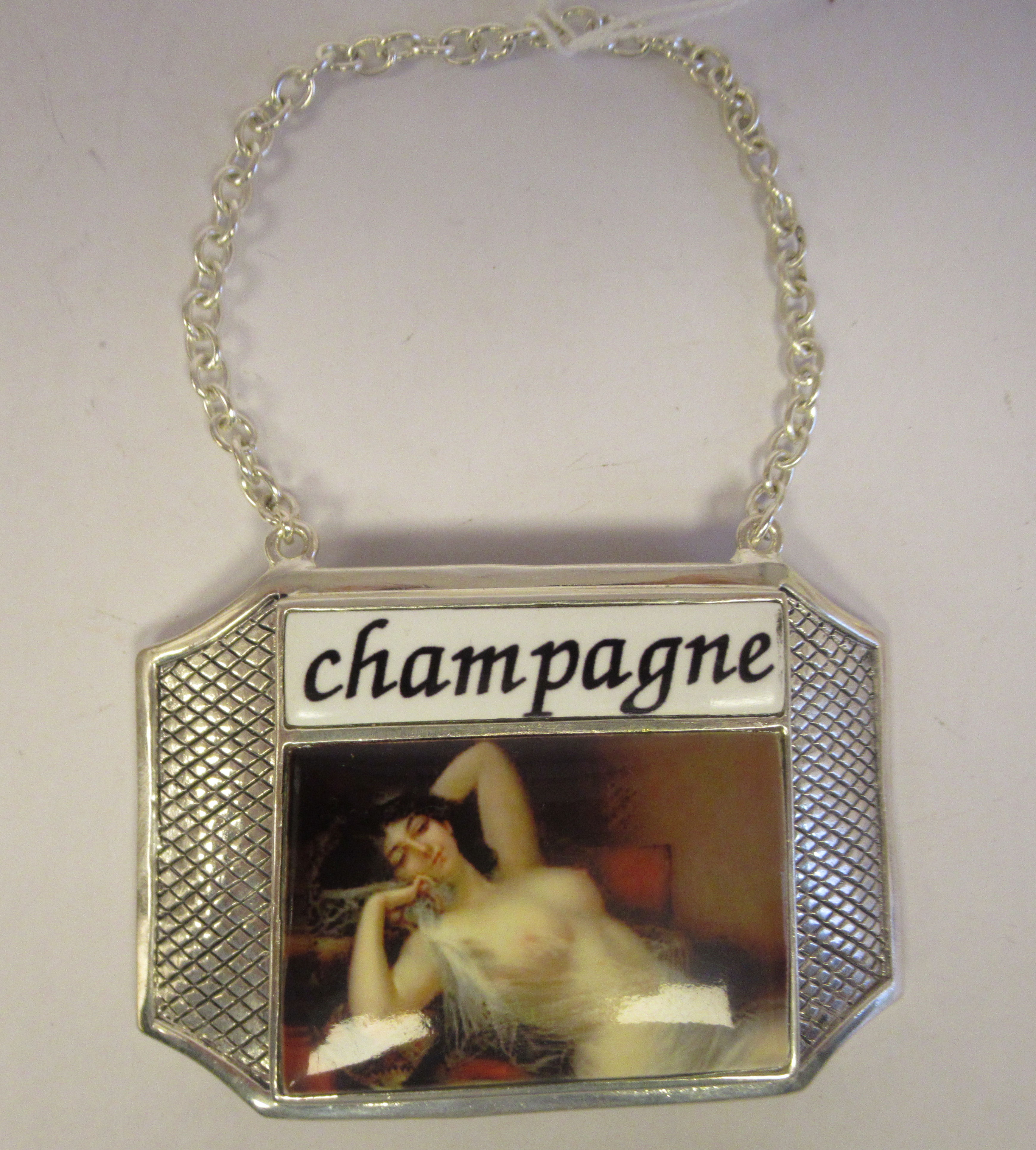 A silver plated and enamelled Champagne label, on a chain