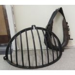 A black painted cast iron wall hanging stable hay rack  38"w; and a horses' collar