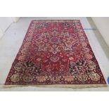 A Persian carpet, profusely decorated with flora and other designs, on a multi-coloured and red