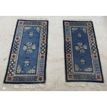 A pair of modern Chinese cotton rugs, decorated in tones of blue and pink with floral and other