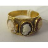 An 18ct gold ring, set with three inline cameo portrait tablets