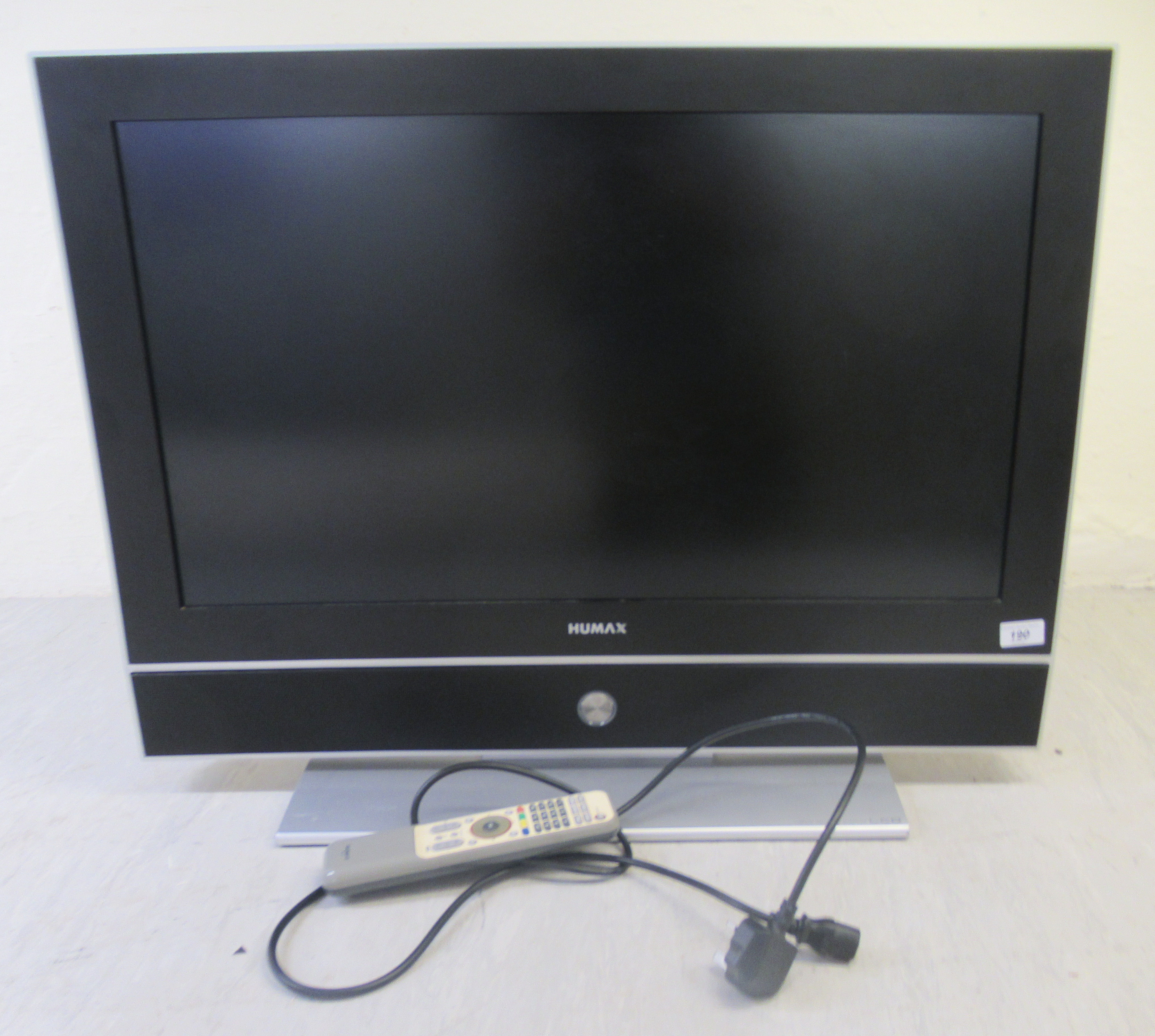 A Humax 27.5'' LCD television, on a table stand with a remote control