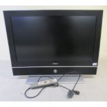 A Humax 27.5'' LCD television, on a table stand with a remote control