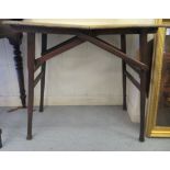 An early 20thC oak and mahogany coaching table with a serpentine outlined top, raised on a