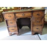 A 20thC lady's walnut figured veneered and crossbanded twin pedestal desk with seven drawers and