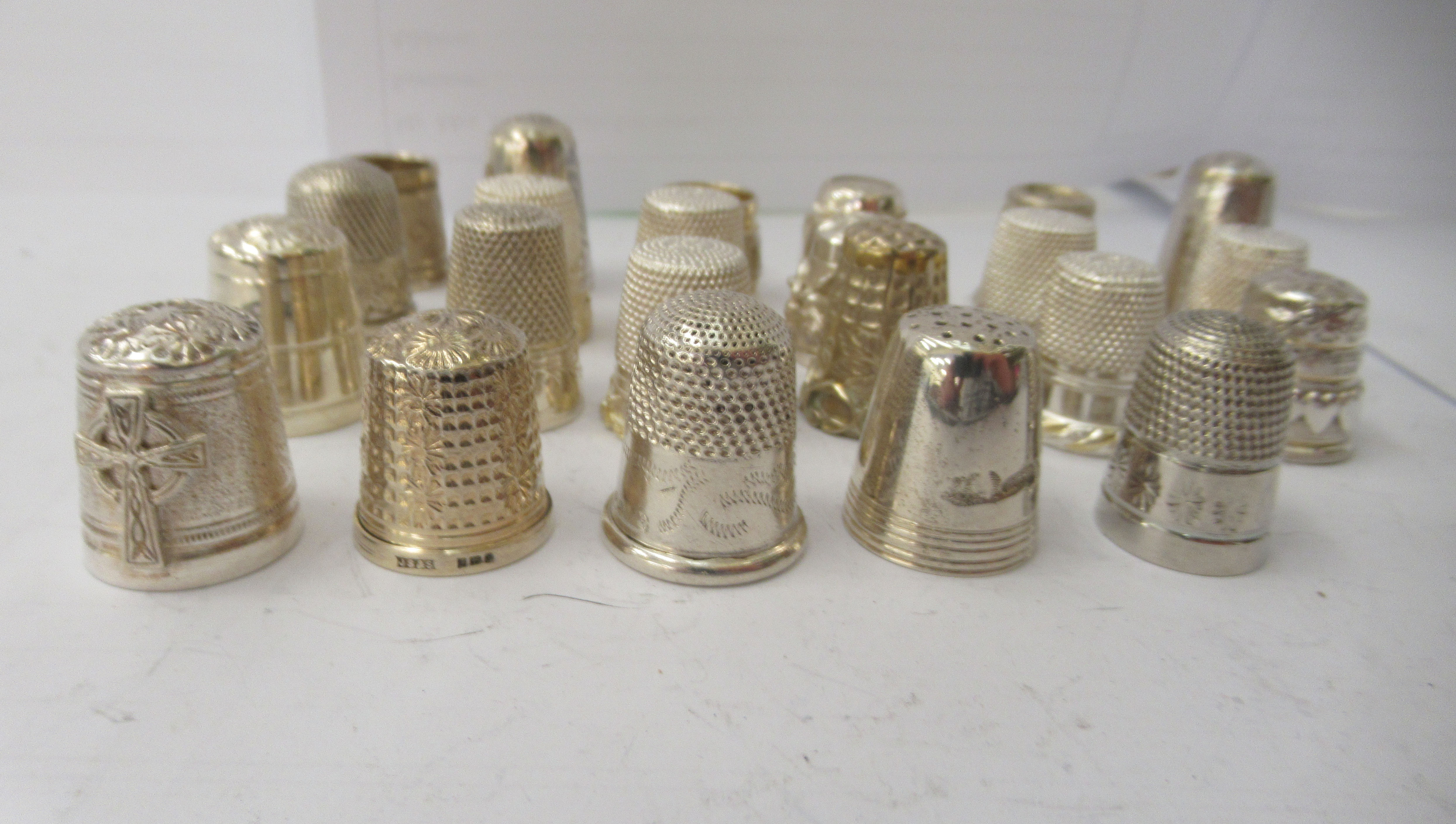 Twenty-two assorted and variously decorated silver, silver coloured and white metal thimbles