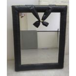 A modern mirror, the bevelled plate set in an overlapped black and gilt fabric frame  24'' x 33''