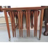 A nesting set of four 1970s folding teak occasional tables with oval tops, suspended from a 'parent'