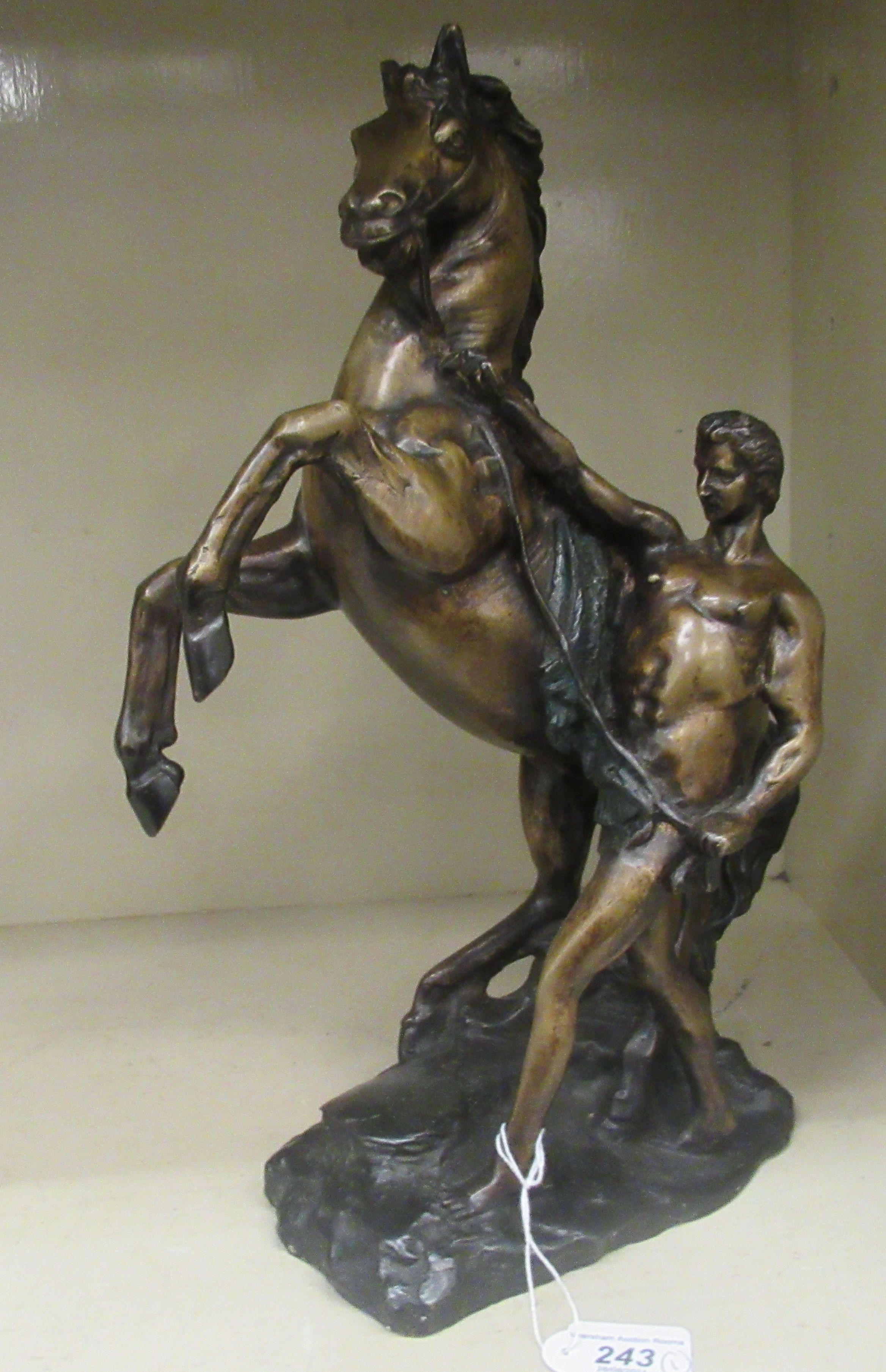 A modern cast bronze Marli inspired sculpture, a man tending to a rearing horse, on a plinth  16"h