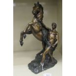 A modern cast bronze Marli inspired sculpture, a man tending to a rearing horse, on a plinth  16"h