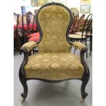 A late Victorian walnut framed spoonback salon chair, upholstered in gold coloured fabric, raised on