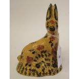 An early 19thC Staffordshire earthenware model, a seated, alert hare with painted red and black