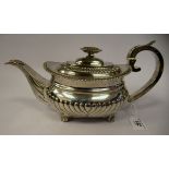 A George III silver teapot of squat, bulbous circular form with floral and foliate cast ornament,