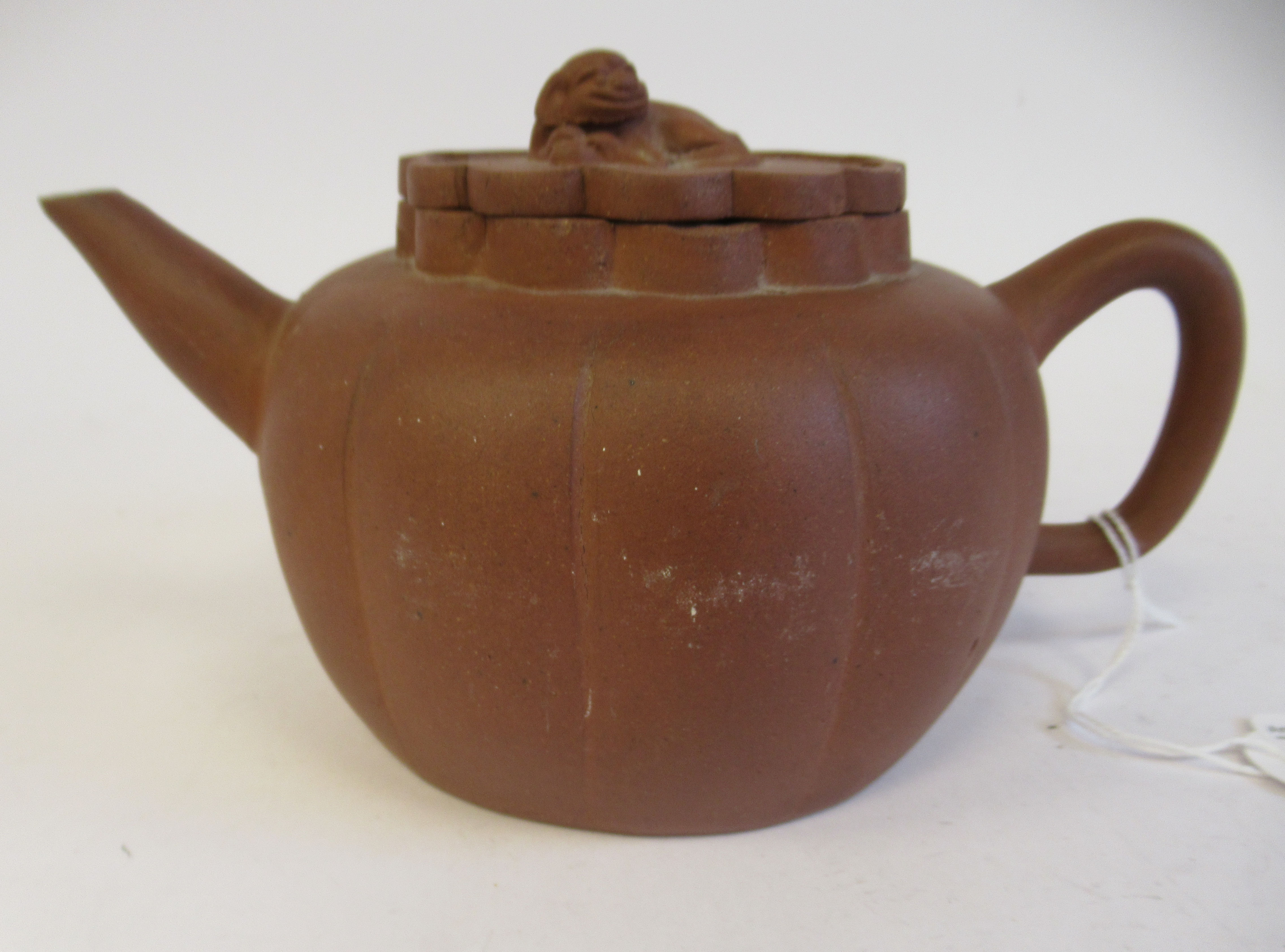 A mid 19thC Chinese Yixing terracotta teapot of segmented, squat, bulbous form with a kylin on the