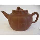 A mid 19thC Chinese Yixing terracotta teapot of segmented, squat, bulbous form with a kylin on the