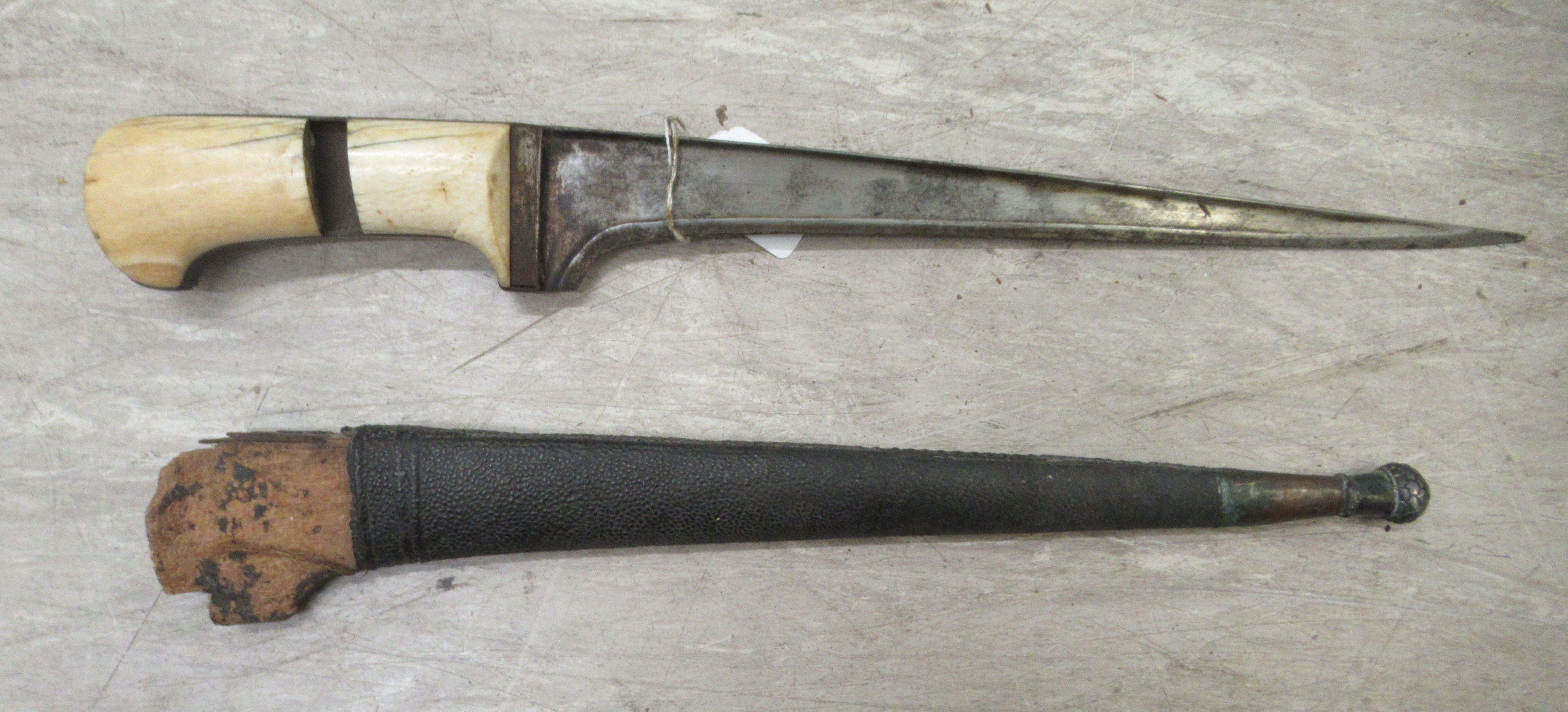 A late 19thC Indo-Persian Pesh-Kabz dagger, on an ivory clad handle  the blade 12"L in a hide