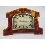 An Art Deco silver coloured metal cased mantel timepiece, set in a shaped tortoiseshell surround, on