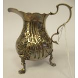 A George III silver cream jug of waisted bulbous form with a decoratively cut, flared wavy rim, a