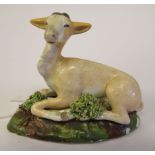 An early 19thC Pearlware model, a seated goat, on a naturalistic base  2.25"h