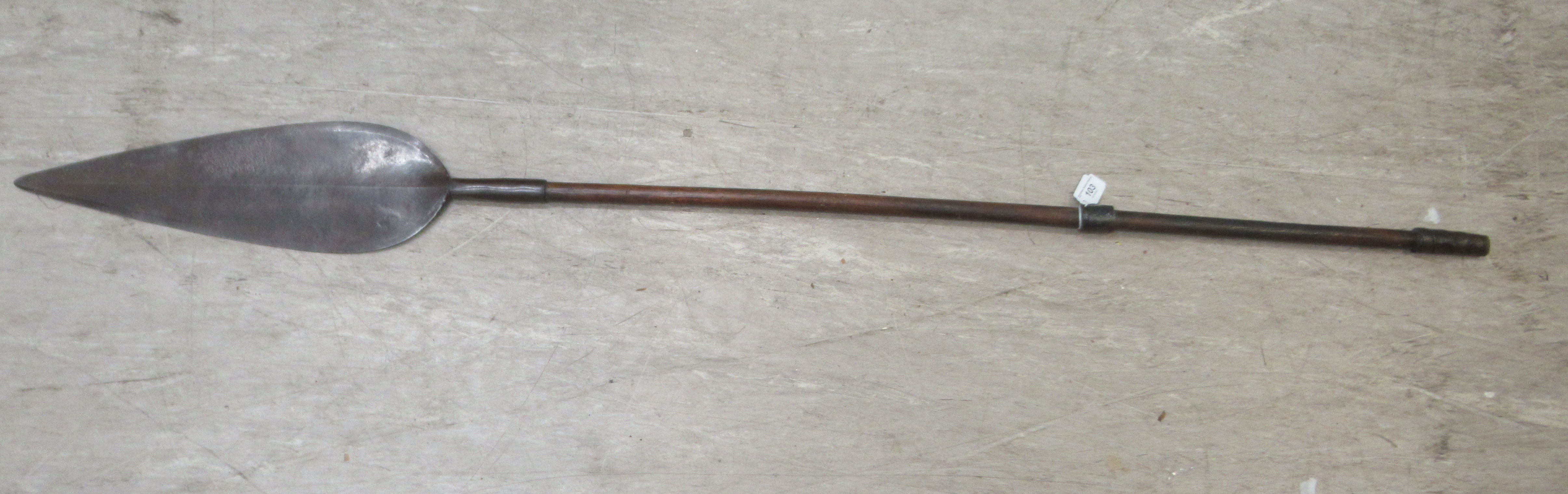 A 20thC African Zulu Iklwa spear with a broad leaf blade and a hardwood shaft, wrapped with spiral