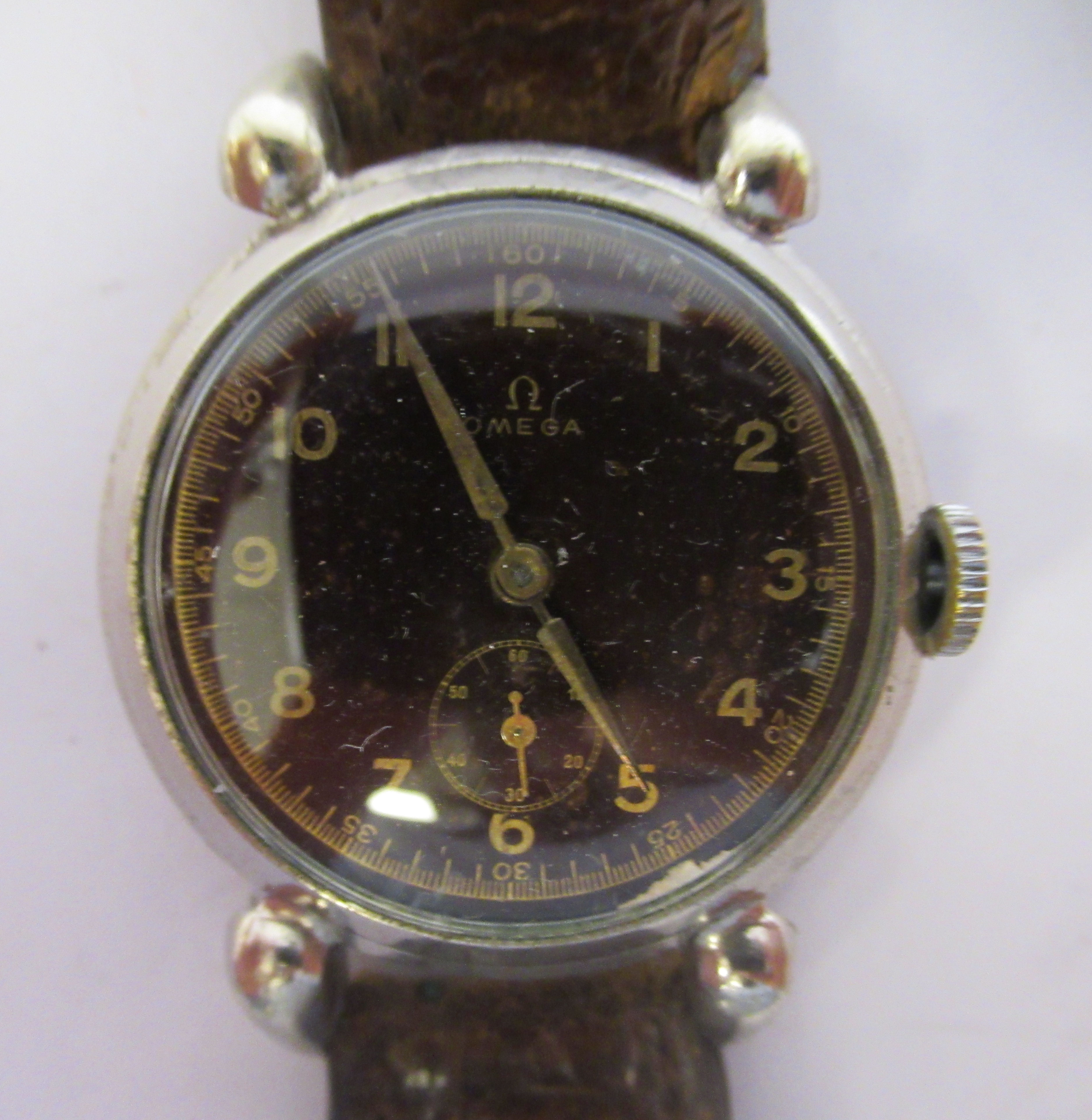 A 1933 Omega chromium plated crab cased wristwatch, faced by a black Arabic dial, incorporating