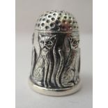 A Sterling silver thimble, decorated with a frieze of seated cats