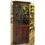 A late 19thC oak two part corner unit, the upper section with a glazed door, over a lower twin