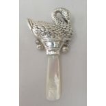 A baby's silver rattle, in the form of a swan, on a mother-of-pearl teething stick