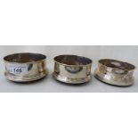 A pair of modern silver wine coasters, on turned mahogany bases; and another similar with a