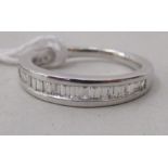 An 18ct white gold, half eternity ring, set with baguette cut diamonds