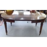 A late Victorian mahogany wind-out dining table, raised on tapered, pillared, reeded legs and
