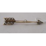 A gold coloured metal and seed pearl set, arrow design brooch
