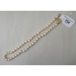 A tinted pink, cultured pearl necklace, on an 18ct gold clasp