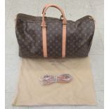 A Louis Vuitton twin handled holdall with a shoulder strap and dedicated dust bag