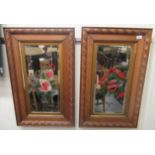 A pair of late Victorian mirrors, each with floral bouquet painted bevelled plate, in an oak