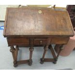 A Queen Anne and later walnut and other clerks desk with a hinged fall flap, enclosing a fitted