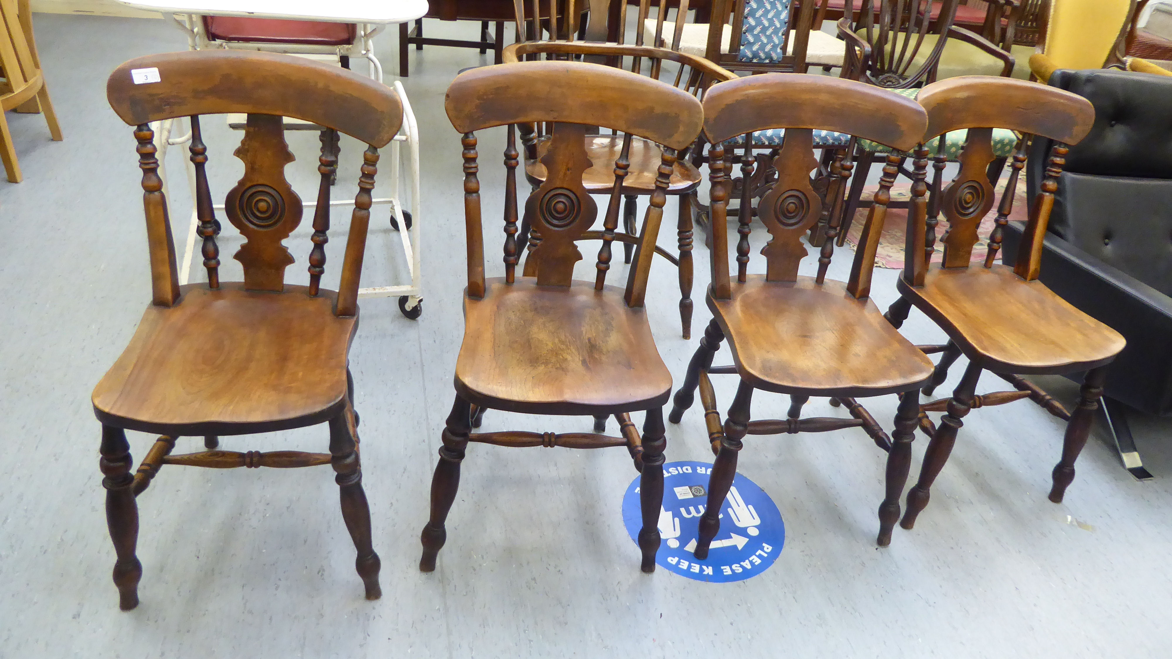 A set of four late Victorian beech and elm framed Windsor chairs, each with a spindled and roundel