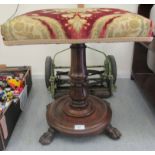 A William IV rosewood stool with a tapestry upholstered top over a tulip carved column, on lion