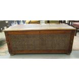 A 1930s oak blanket chest with straight sides and a hinged lid with cane worked panelled ornament,