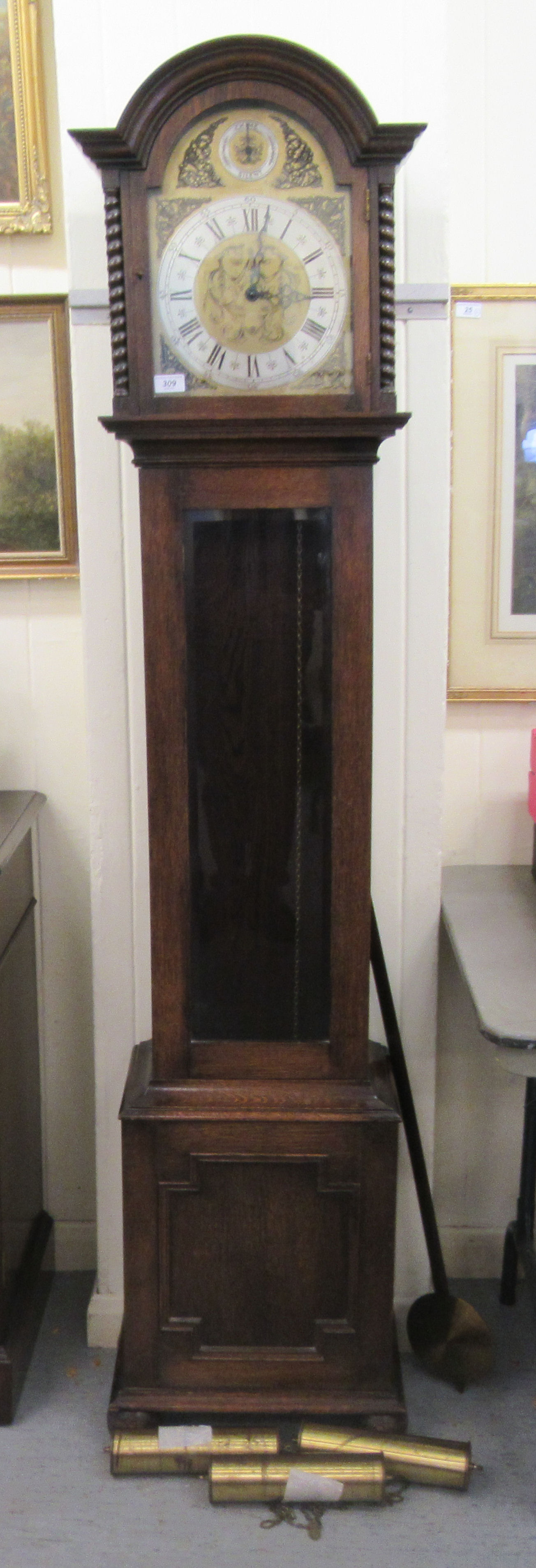 A 1930s oak cased grandmother clock; the weight driven movement faced by a brushed steel Roman dial,