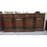 A modern reproduction of a Georgian mahogany finished breakfront sideboard with four frieze drawers,