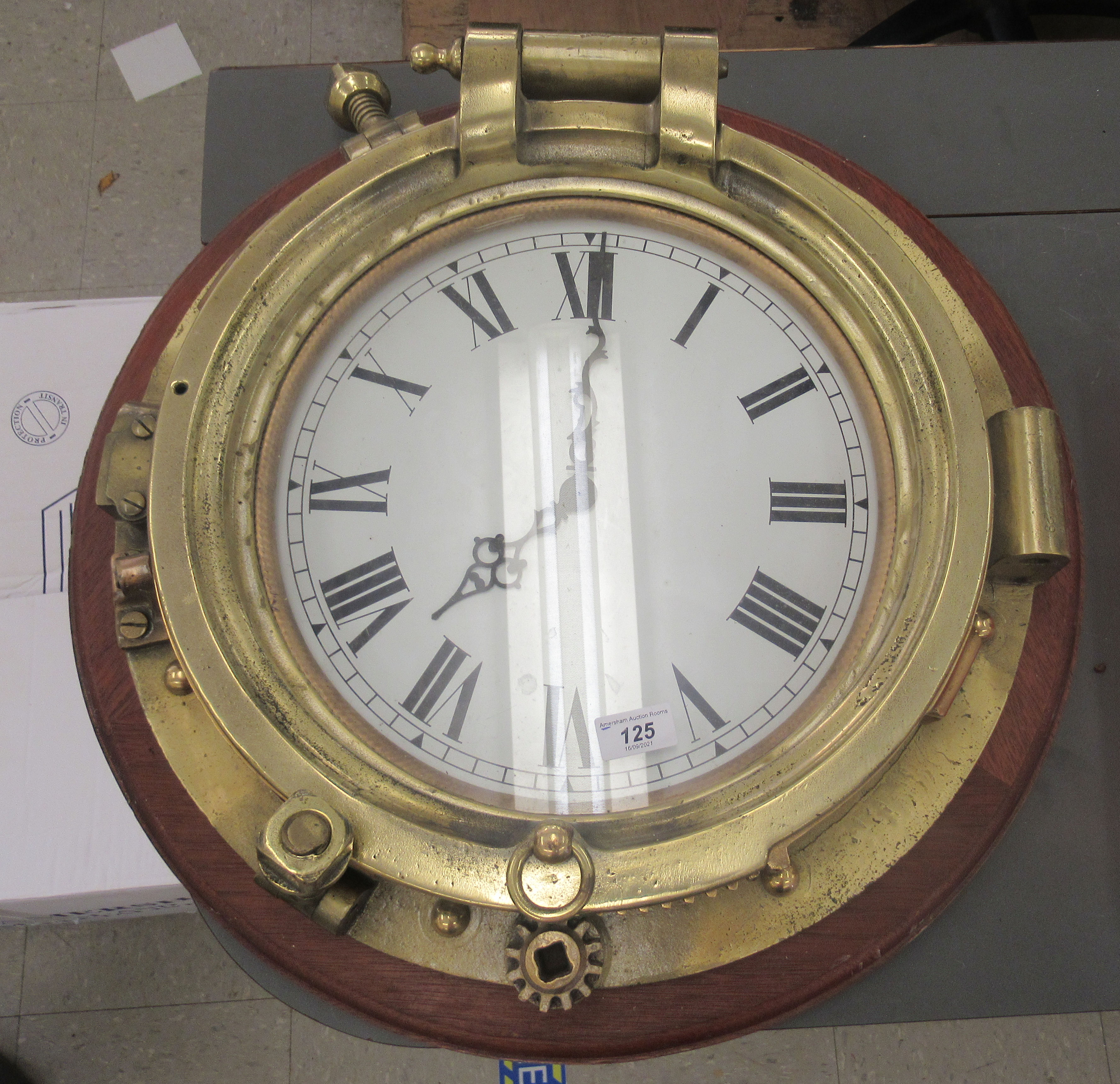 A 20thC brass porthole (diver salvage), later converted to a timepiece, the battery powered movement