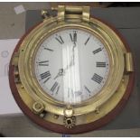 A 20thC brass porthole (diver salvage), later converted to a timepiece, the battery powered movement