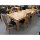 A modern light oak dining table, raised on square, block legs, united by a stretcher  31''h  36"deep