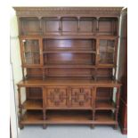 An early/mid 20thC carved oak dresser, the panelled back superstructure with glazed panelled doors