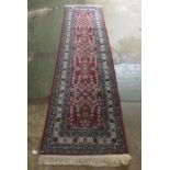 A Persian runner, decorated with floral motifs, on a red and blue ground  134'' x 33''