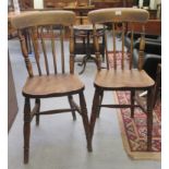 A pair of late 19thC beech and elm framed kitchen chairs, each with a spindled back, the solid